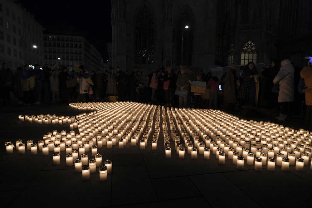 a large group of people standing around candles
