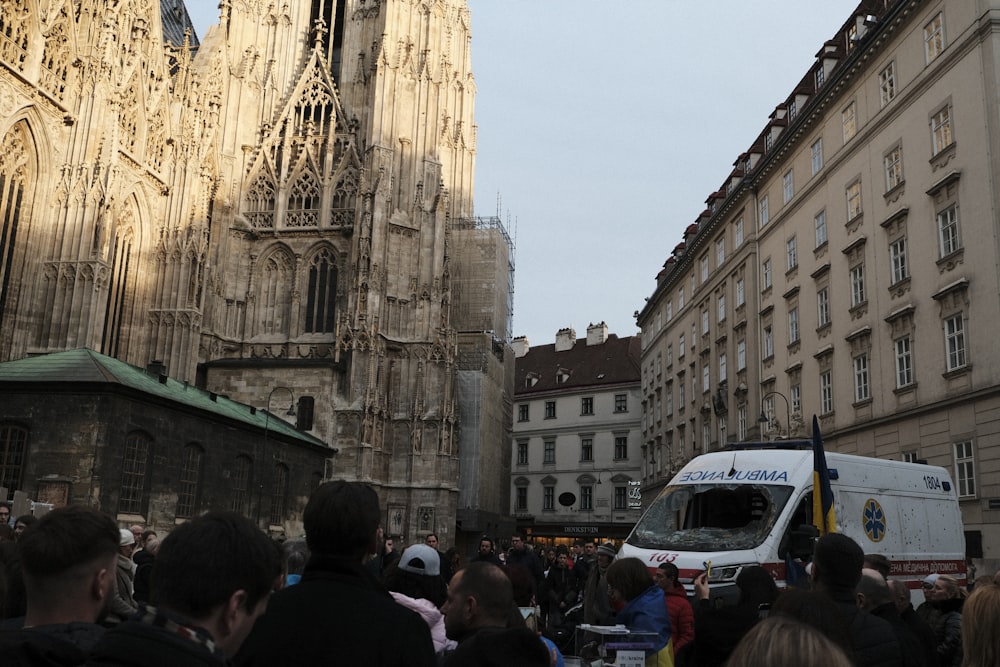 a crowd of people standing around a white van