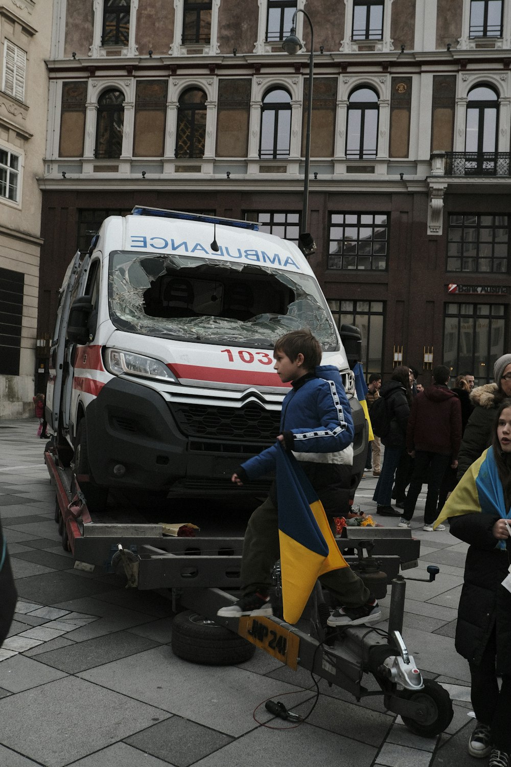 a man sitting on a bike in front of an ambulance