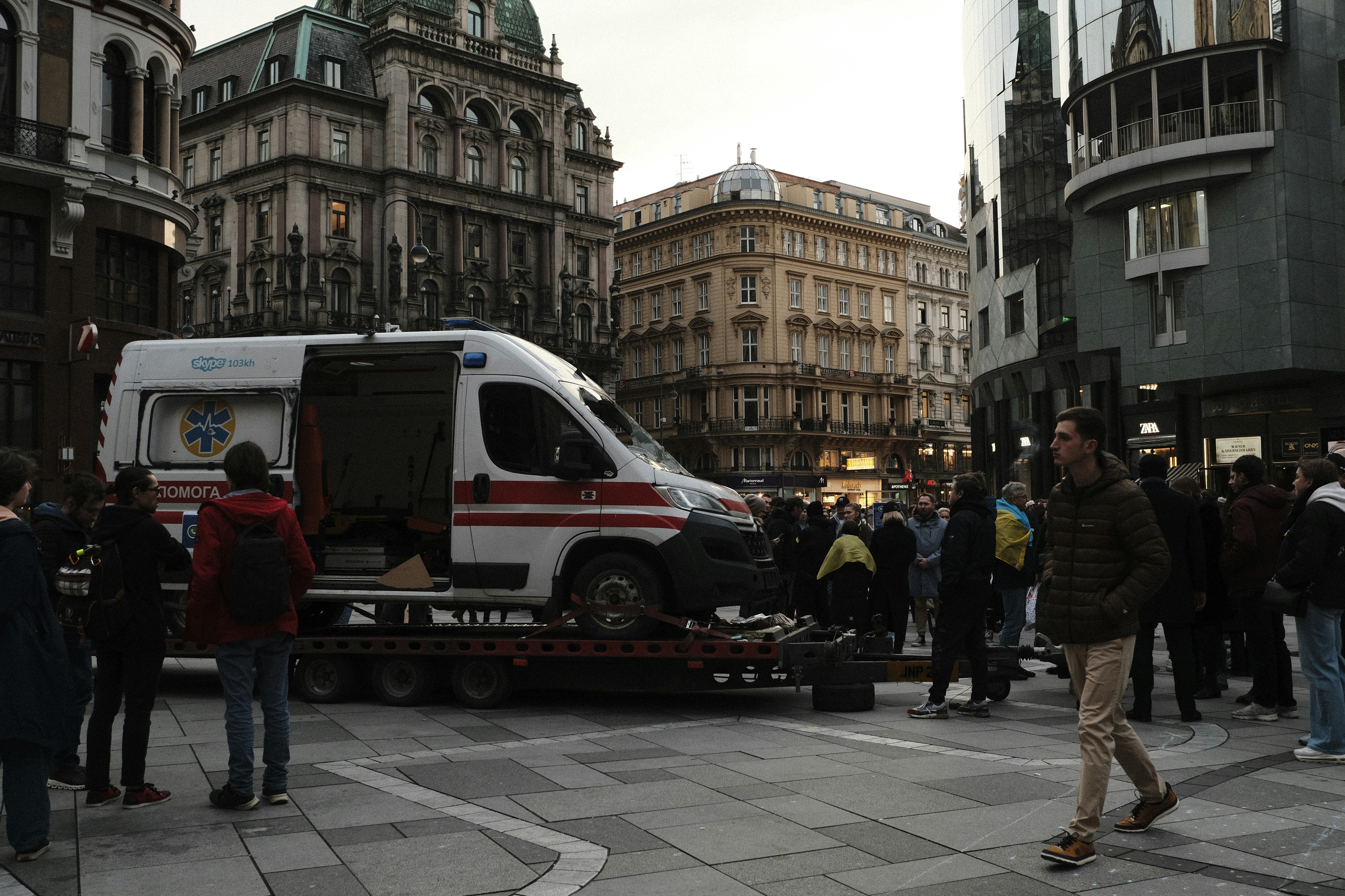 Un grupo de personas de pie alrededor de una furgoneta en una calle de la ciudad