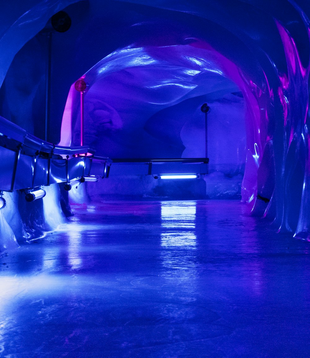 a blue tunnel with benches and lights in it