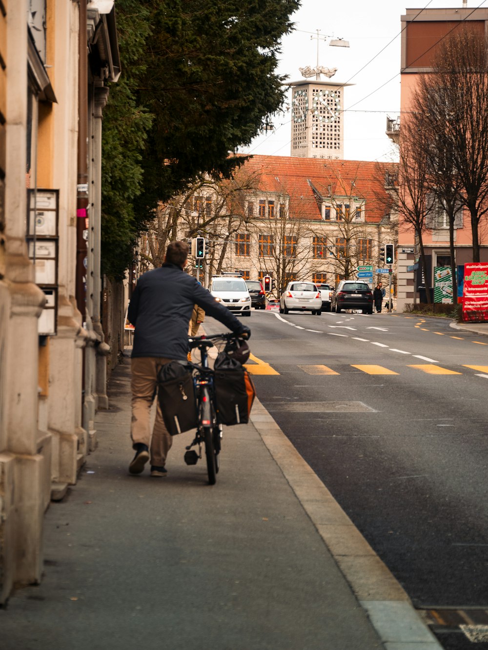 a man riding a bike down a street next to tall buildings