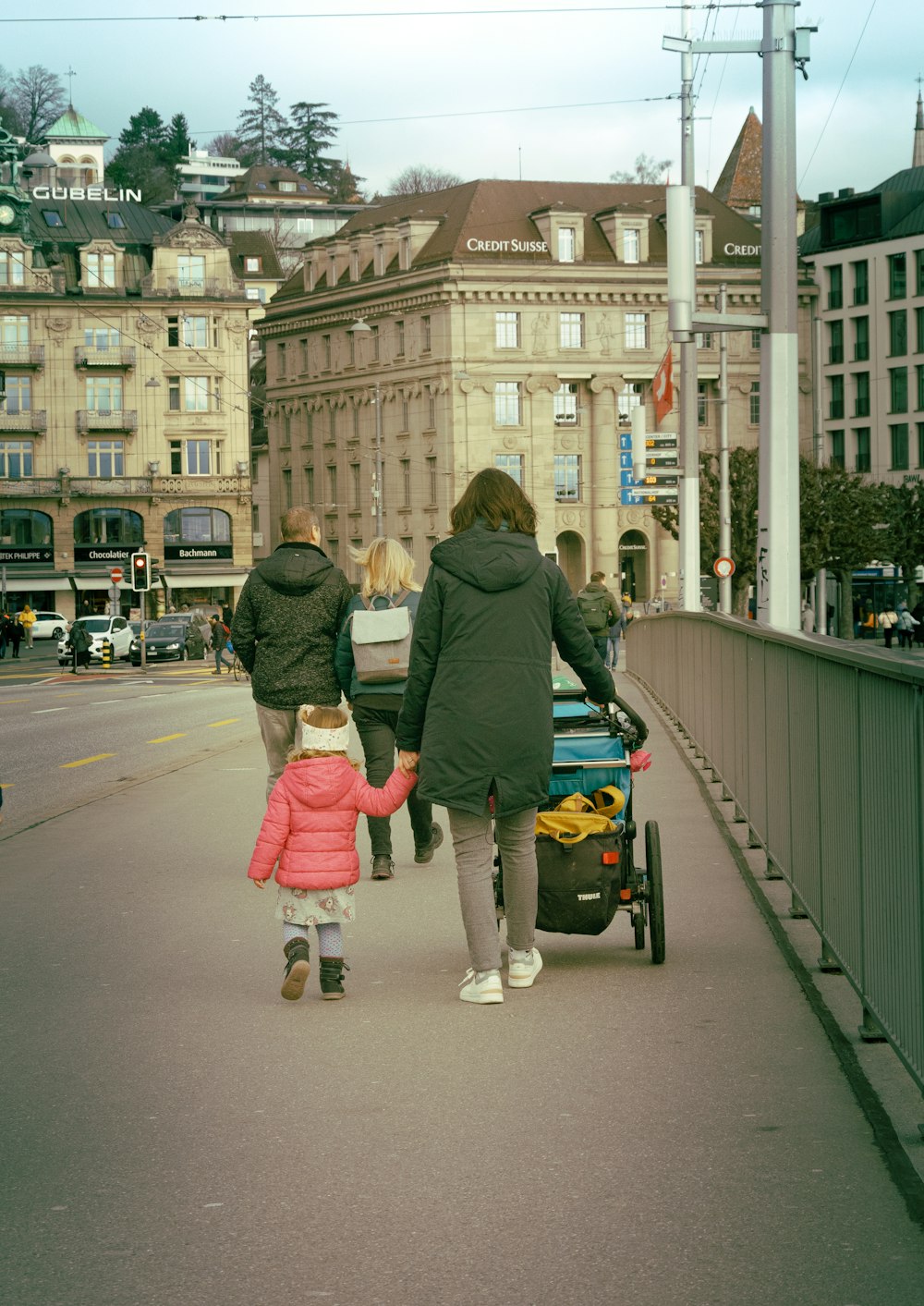 a group of people walking across a bridge