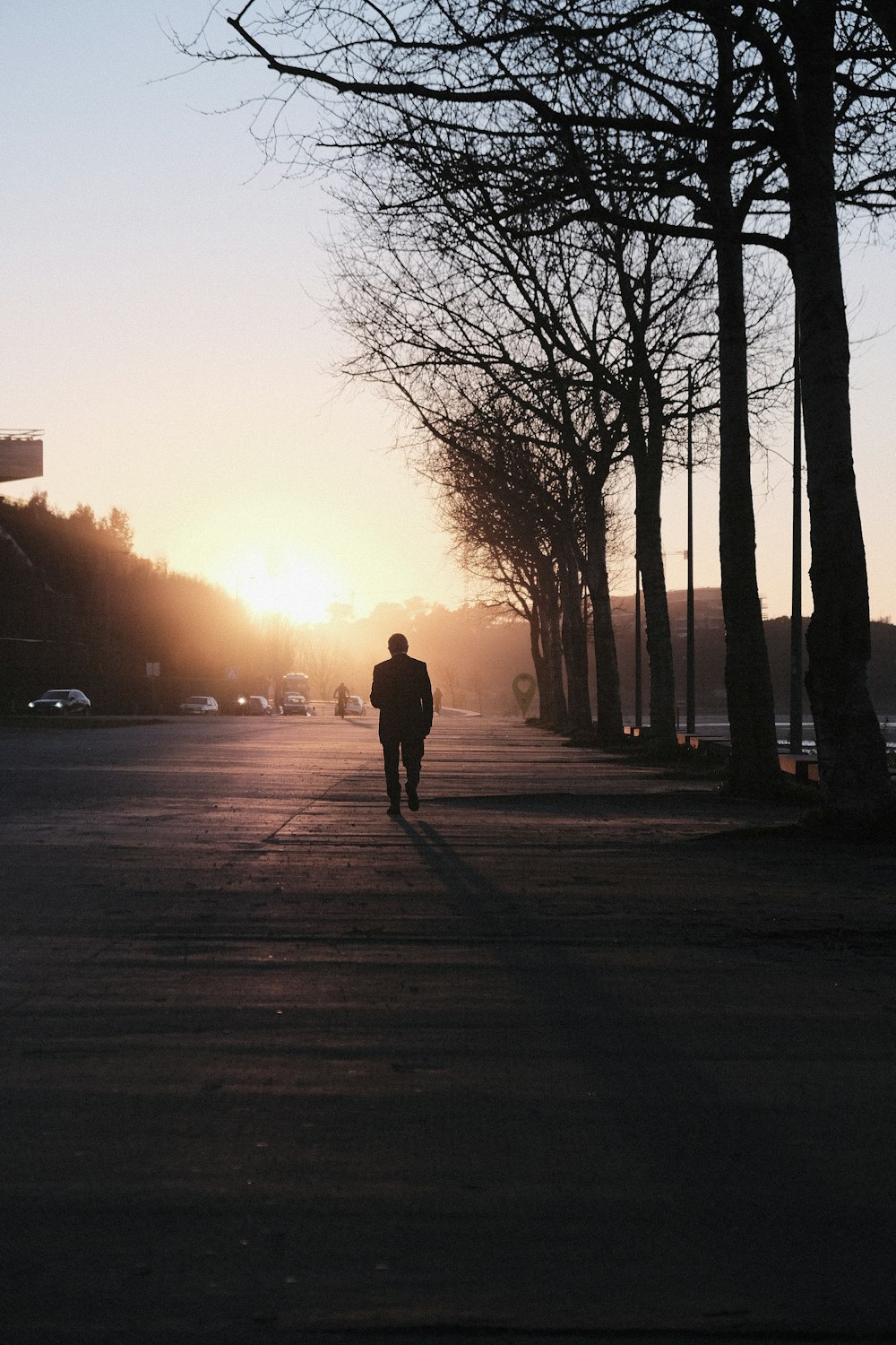 a person walking down a street at sunset