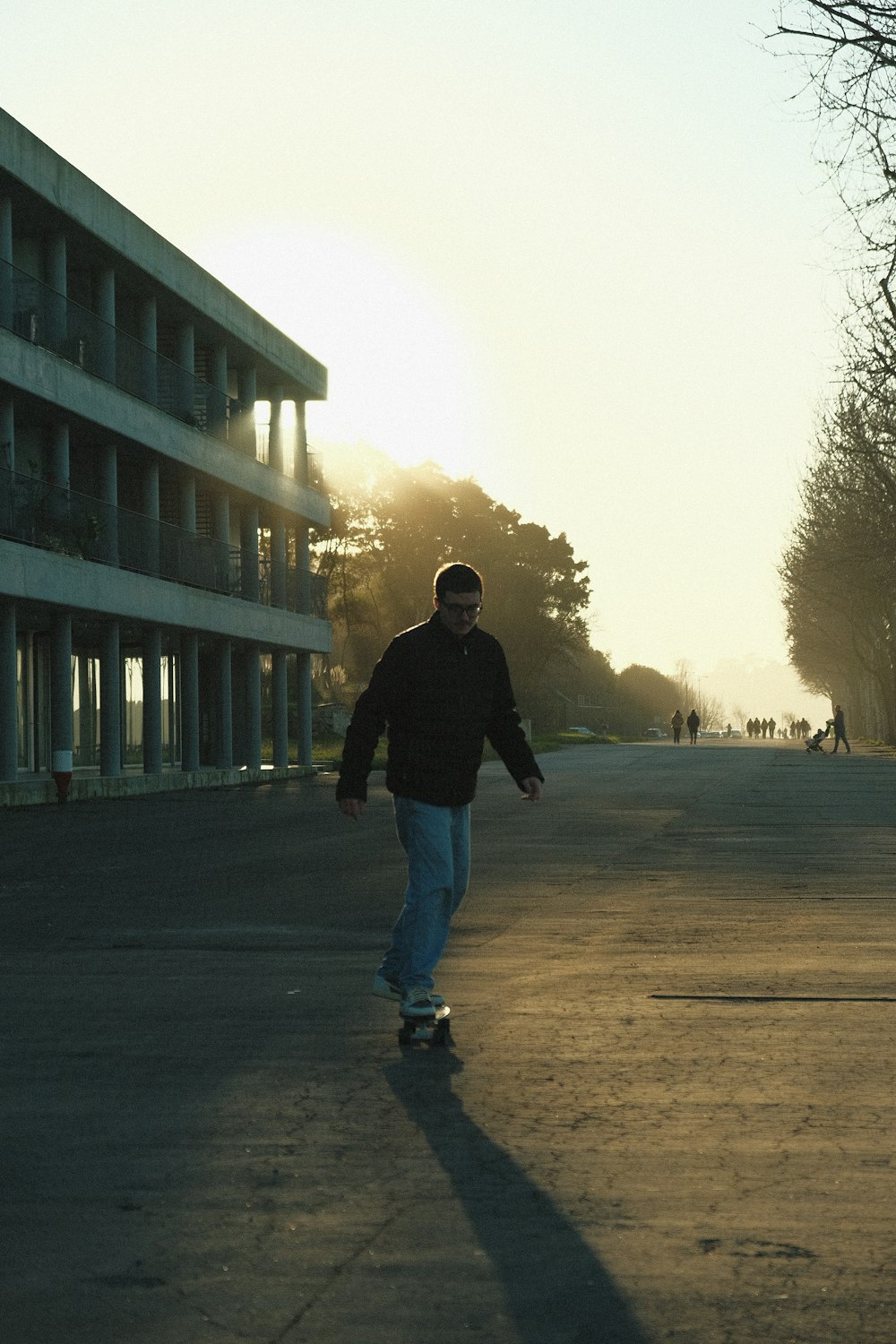 通りをスケートボードで走る男