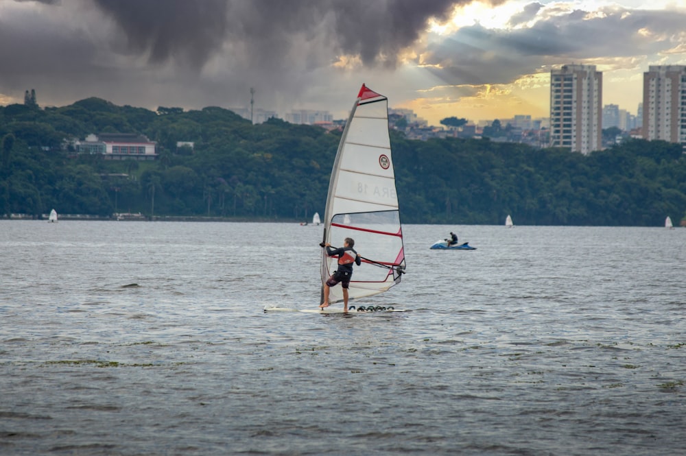 a man riding a sailboat on top of a body of water