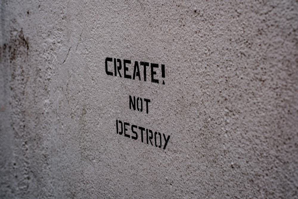 graffiti on a wall that says create not destroy