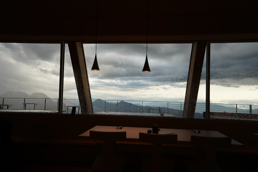 An elegant dining room with floor-to-ceiling windows opening to a mountain view