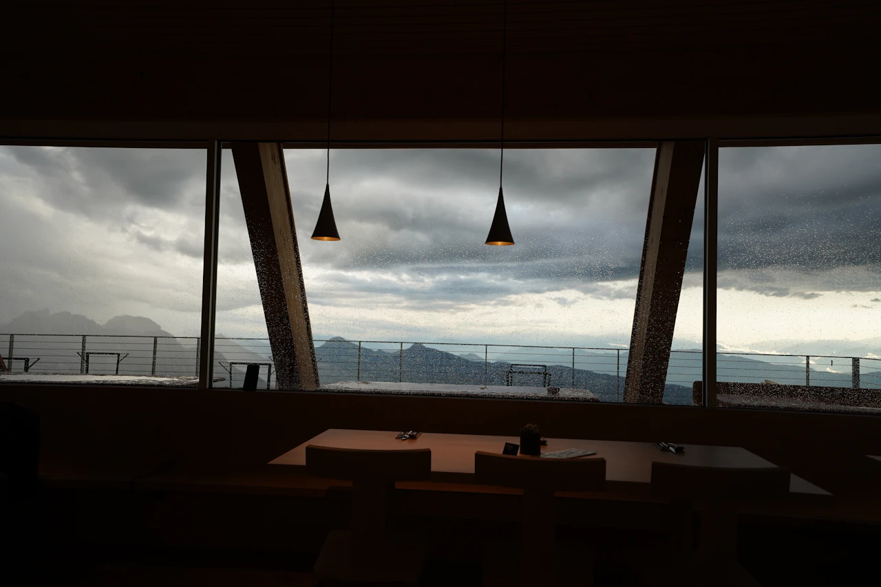 An elegant dining room with floor-to-ceiling windows opening to a mountain view