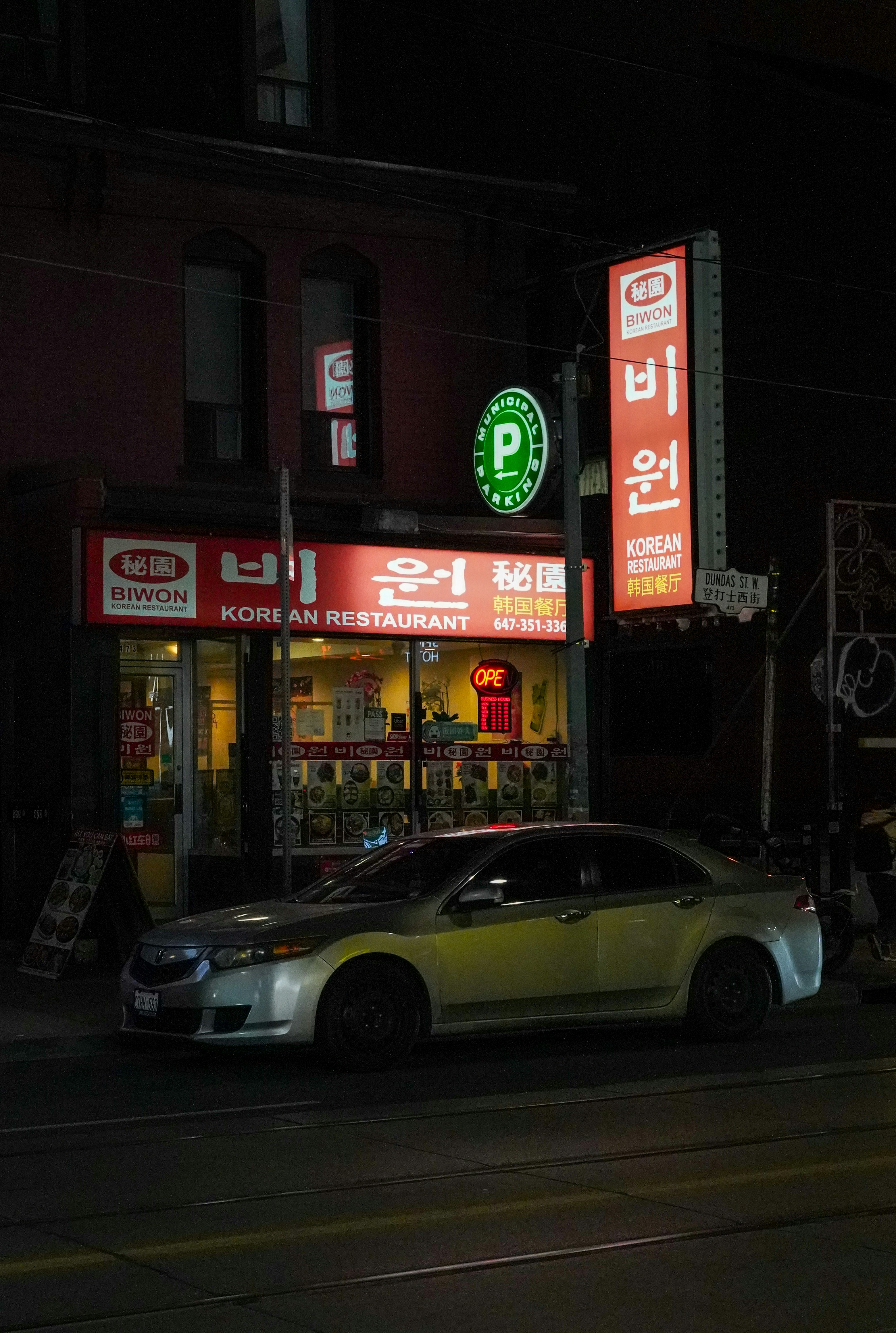 a car parked on the side of a street at night