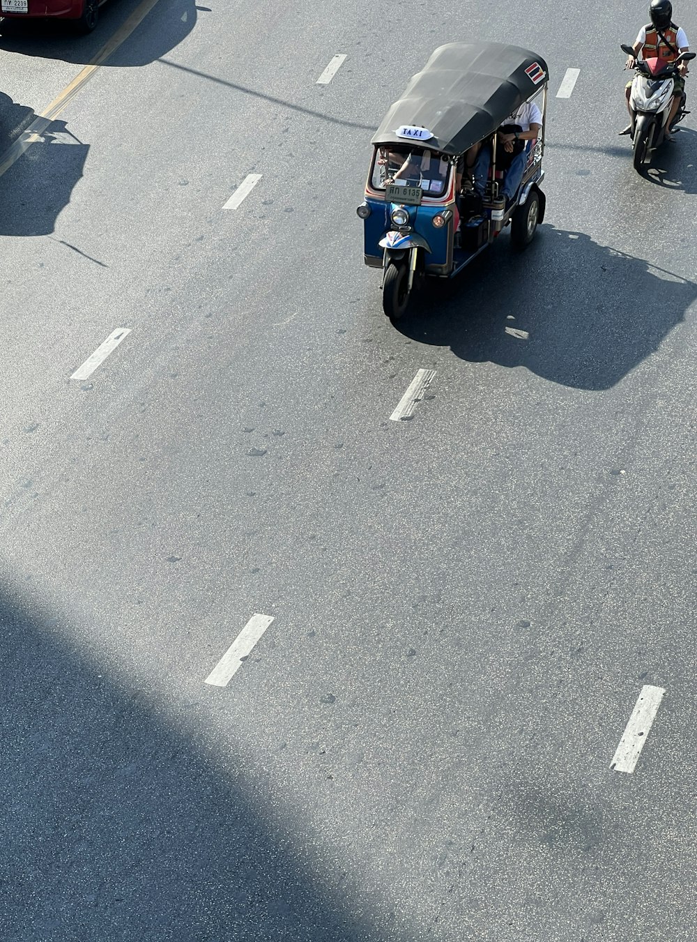 a group of people riding on the back of a motorcycle down a street