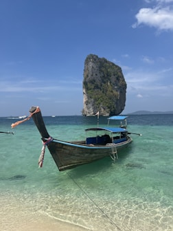 a long boat sitting on top of a sandy beach
