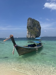 a long boat sitting on top of a sandy beach