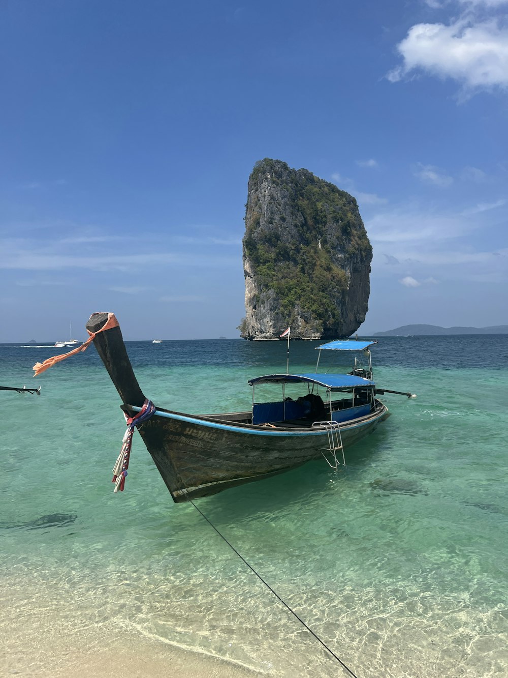 a long boat sitting on top of a sandy beach