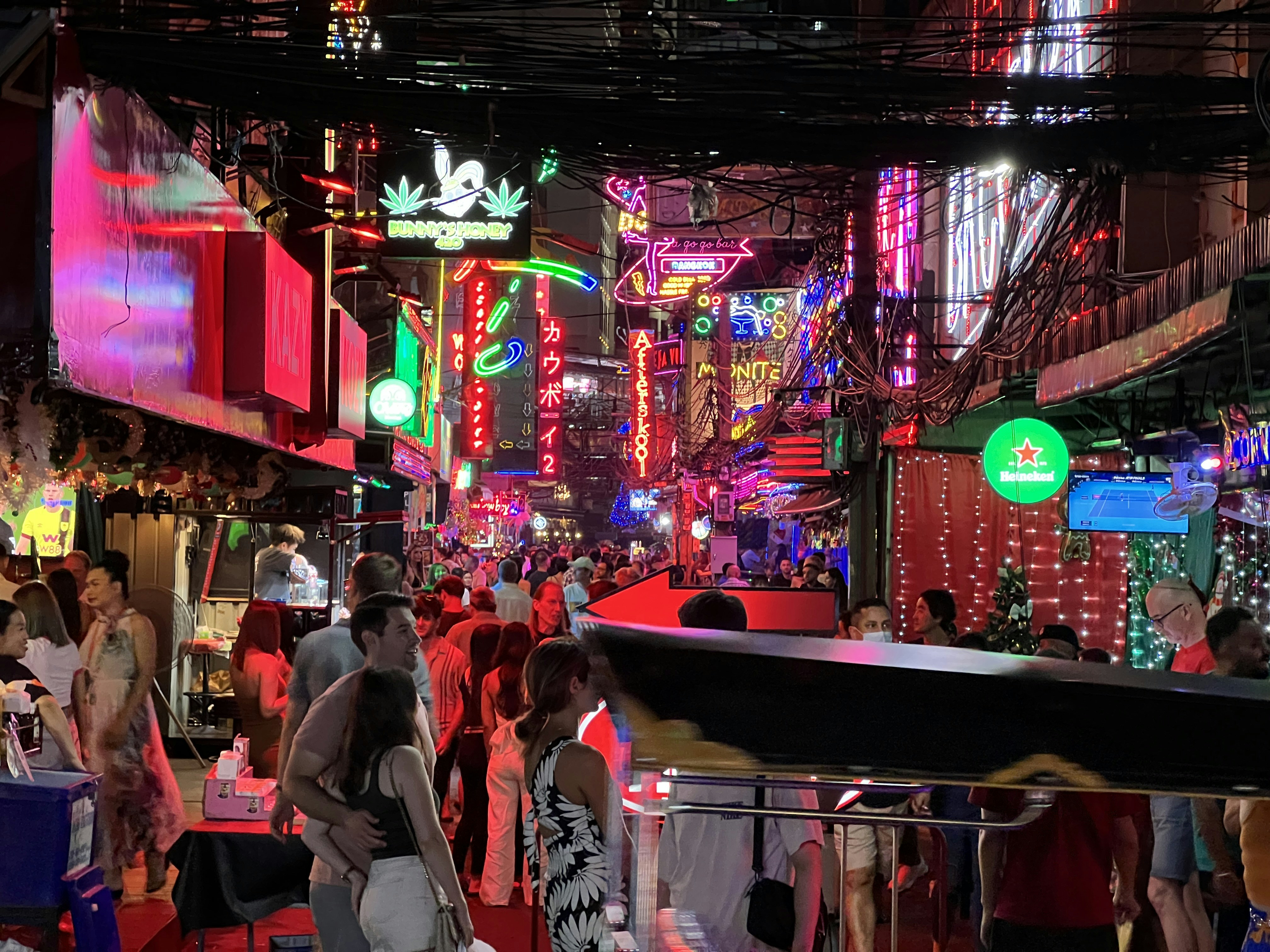 un grupo de personas caminando por una calle por la noche
