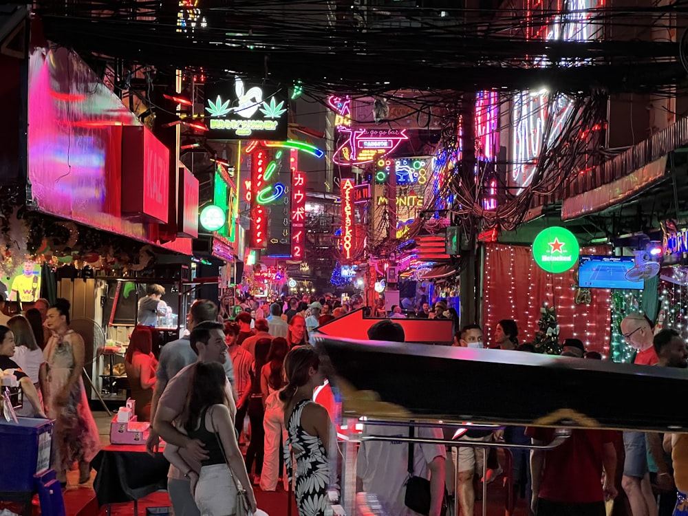 a group of people walking down a street at night