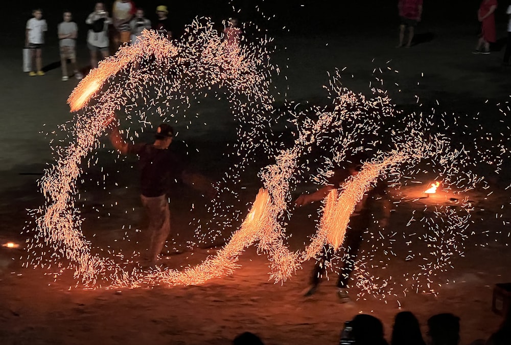 a group of people standing around a fire show