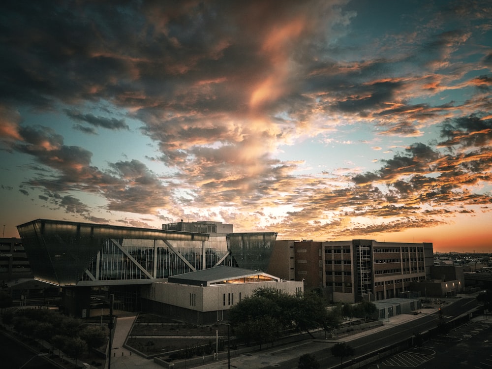 a sunset view of a building with a cloudy sky