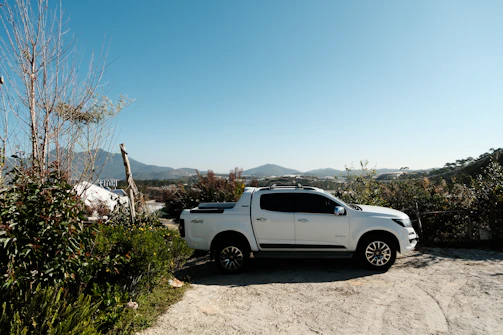 a white pick up truck parked on a dirt road