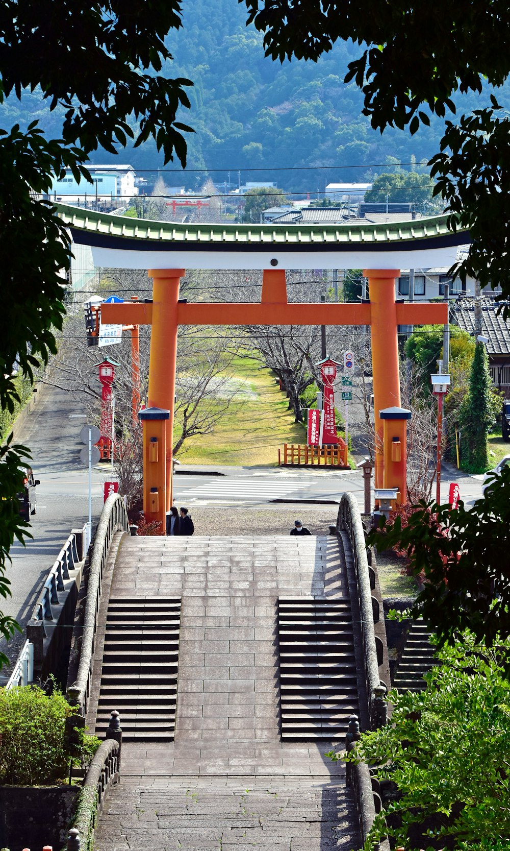 a person sitting on a bench under an orange arch