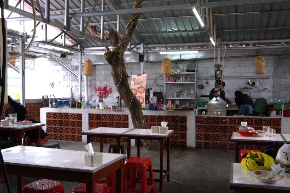 un restaurante con mesas y sillas y un árbol en el centro de la sala