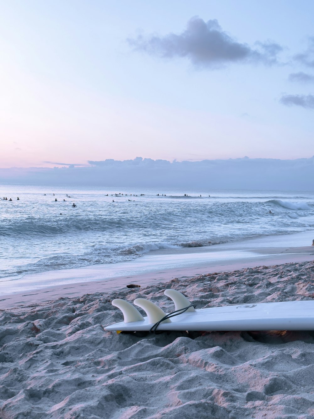 a surfboard laying on the sand of a beach