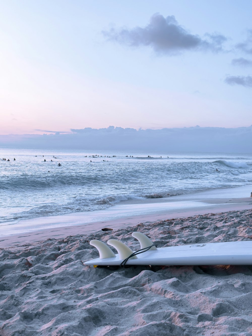 une planche de surf posée sur le sable d’une plage