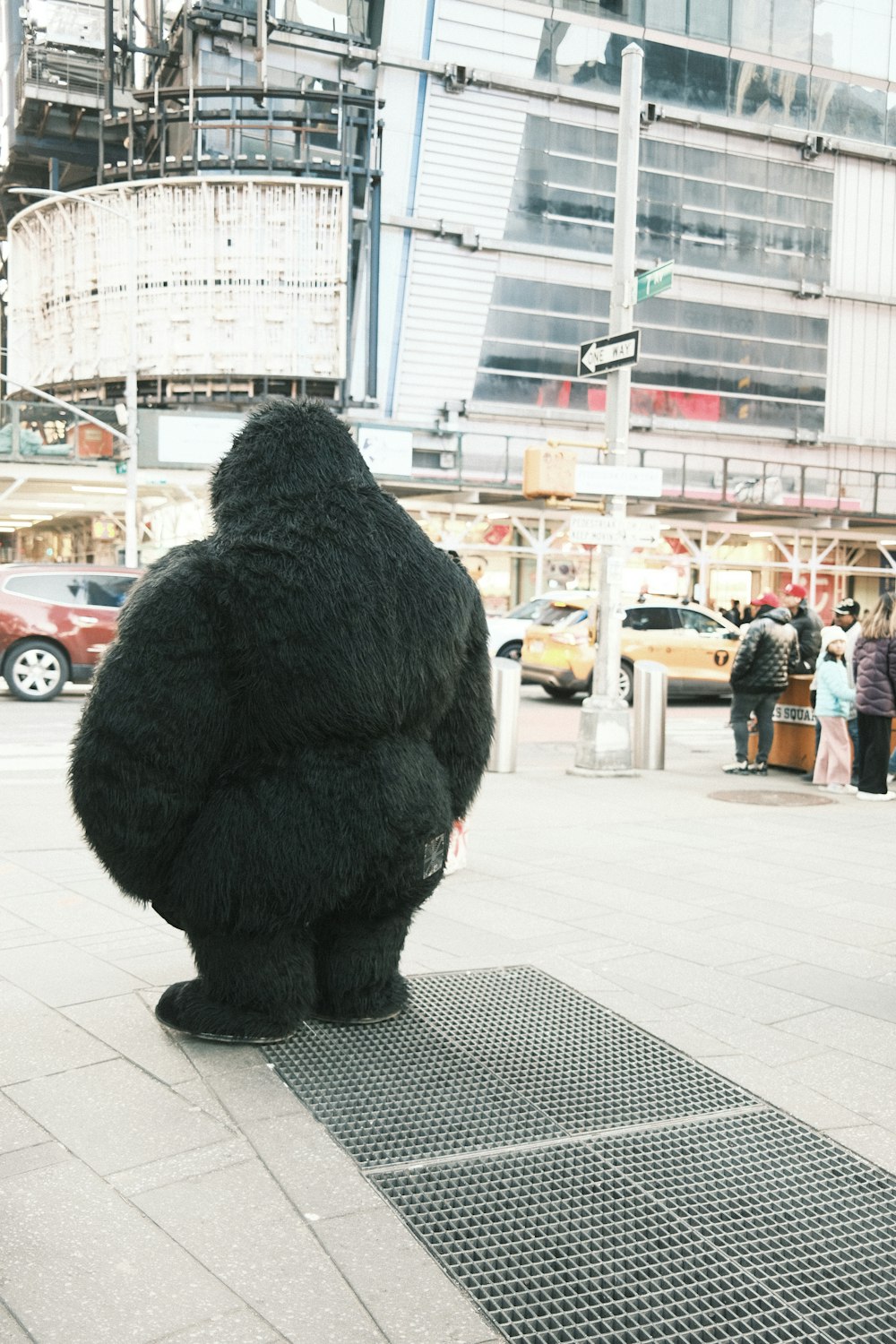 a man in a gorilla suit sitting on a sidewalk
