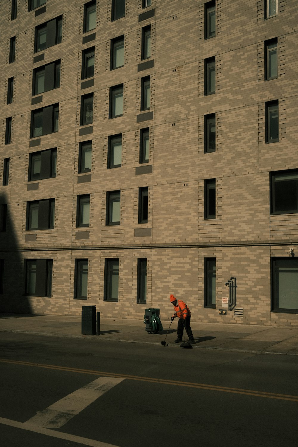 a man walking down a street next to a tall building