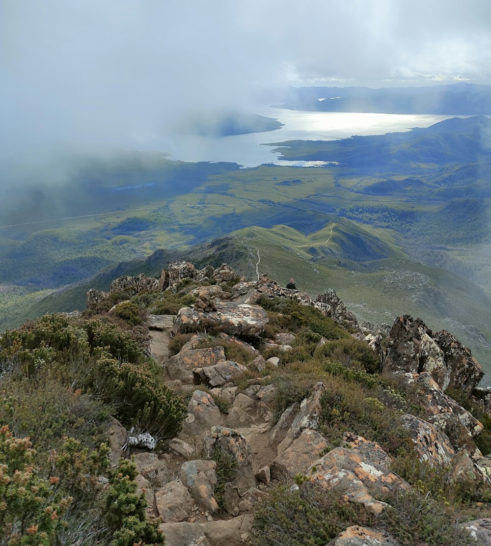 a view of a rocky mountain with a lake in the distance