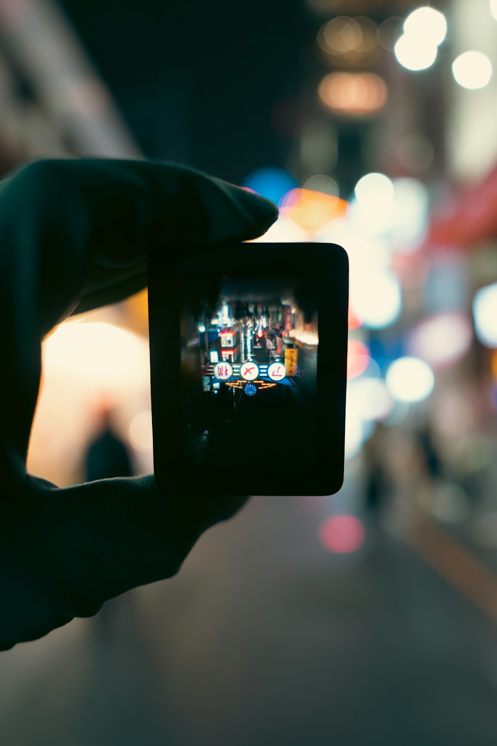 uma pessoa tirando uma foto de uma rua à noite