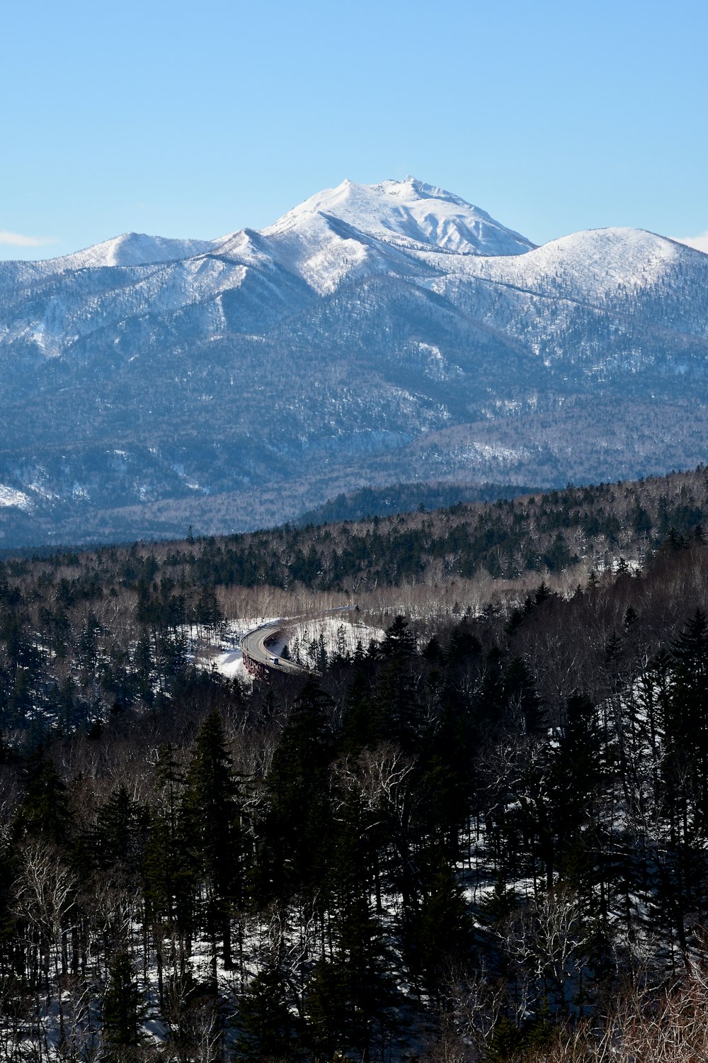 a view of a snowy mountain range with a road in the foreground