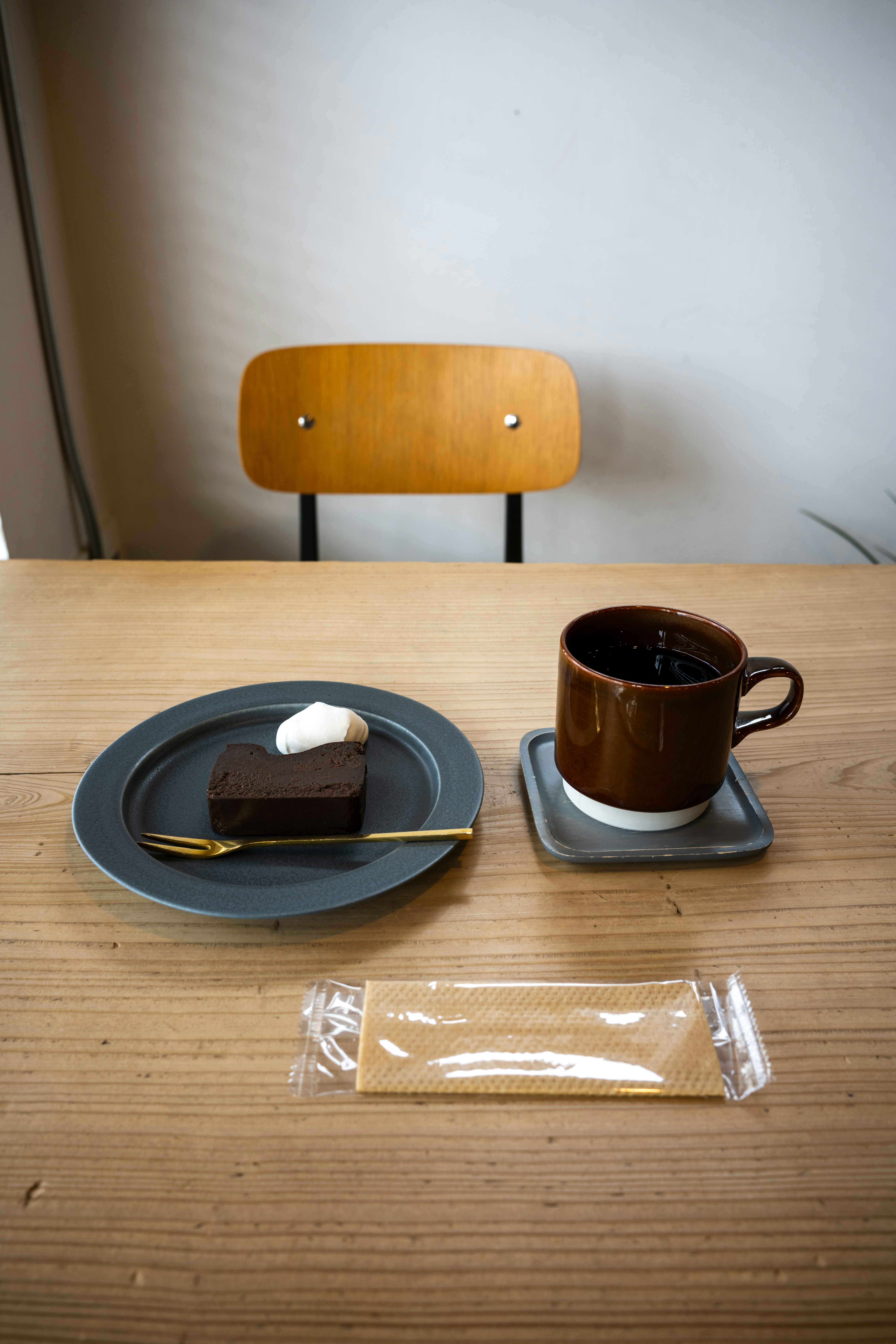 a plate with a piece of cake on it next to a cup of coffee
