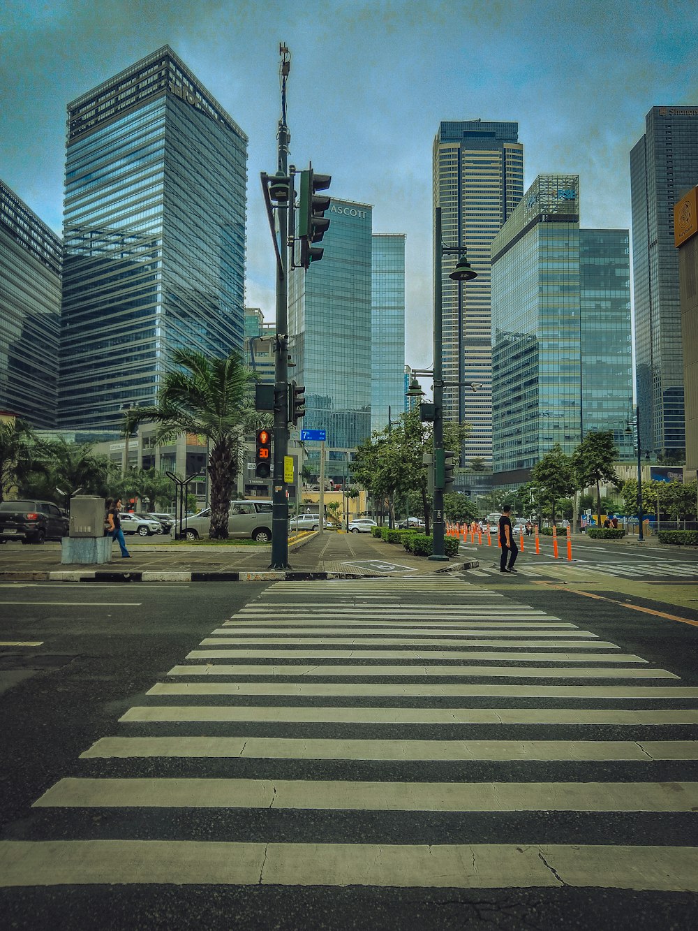 a crosswalk in a city with tall buildings in the background