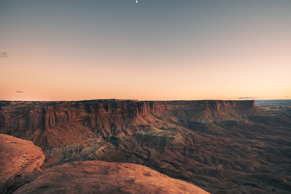 a plane flying over a canyon at sunset