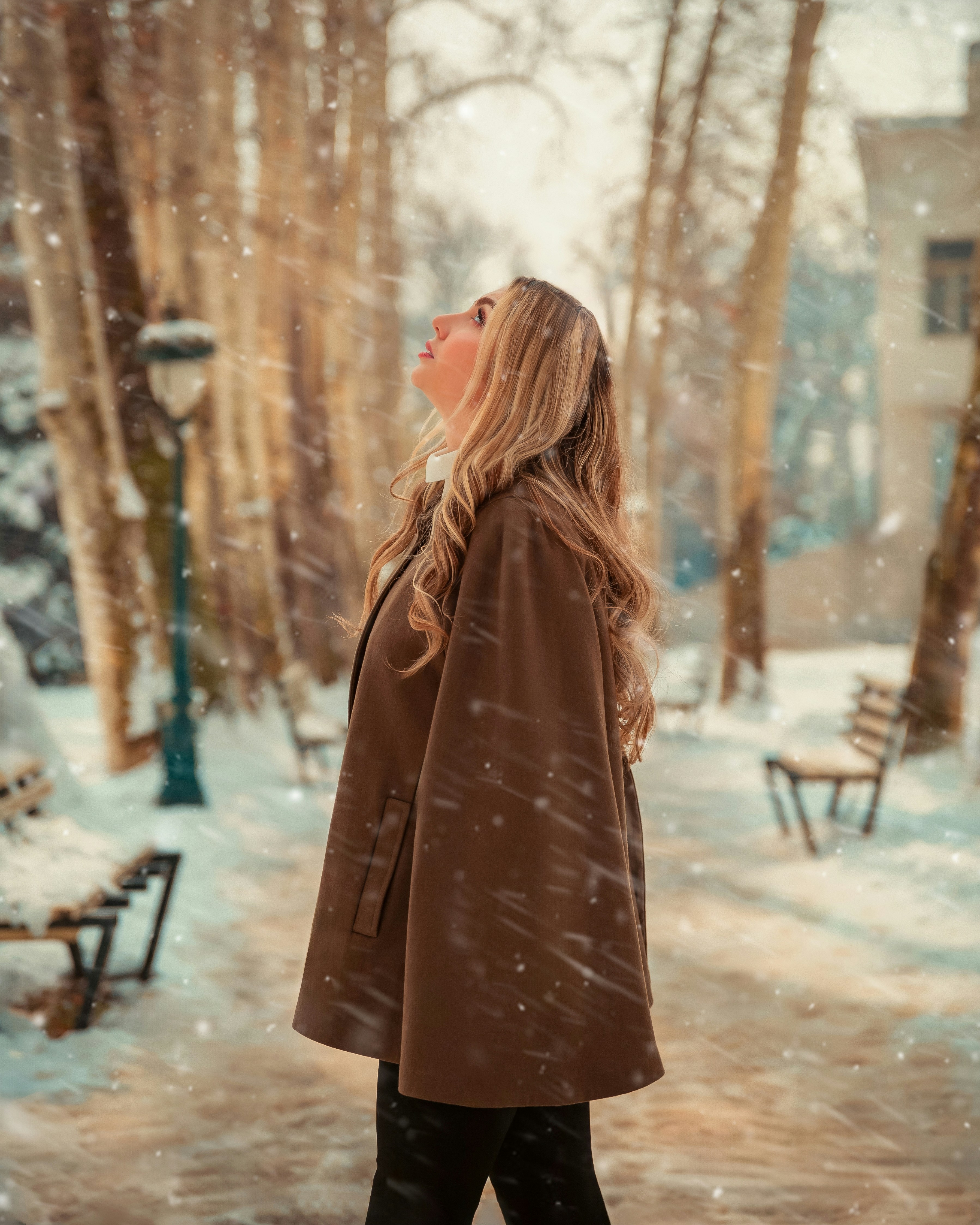a woman in a brown coat is walking through the snow