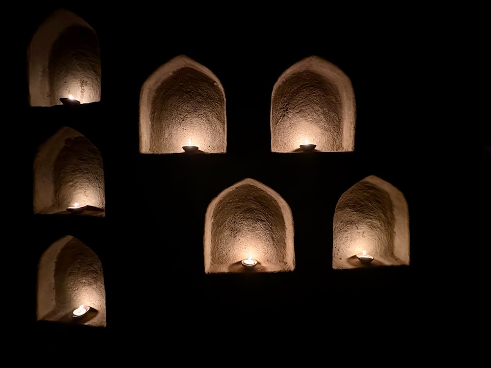un gruppo di candele accese in una stanza buia