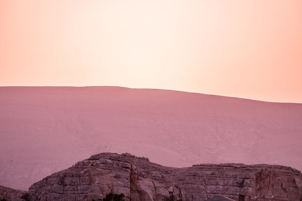 a mountain with a pink sky in the background