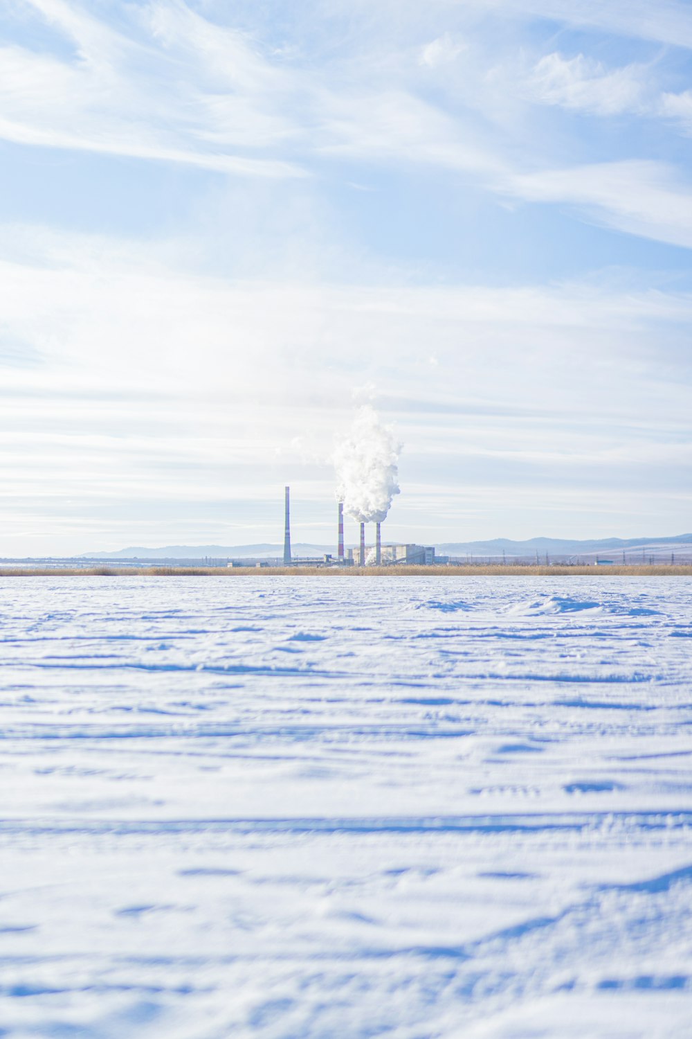 una fabbrica in lontananza con la neve a terra