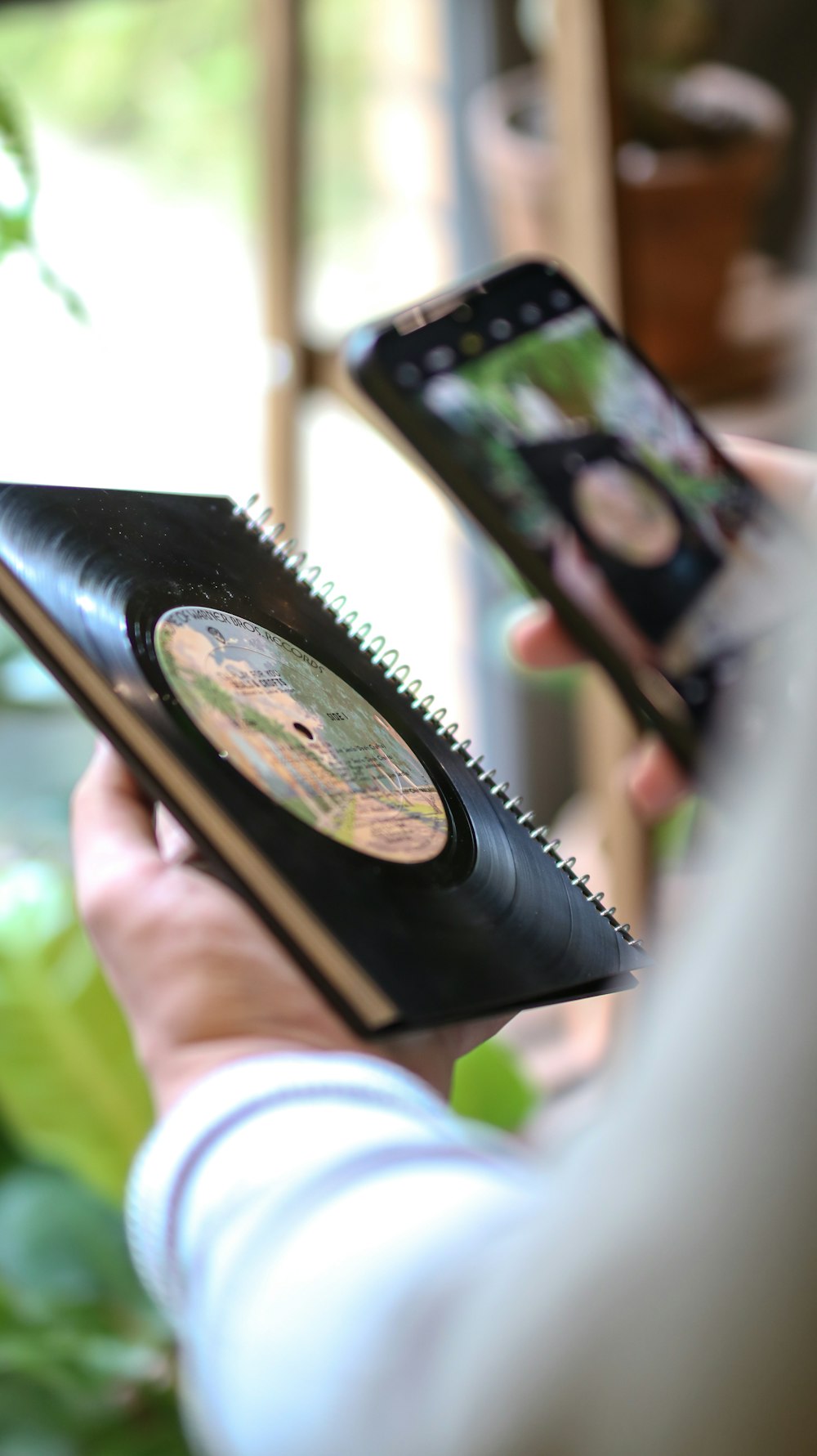 a person holding a notebook and a cell phone