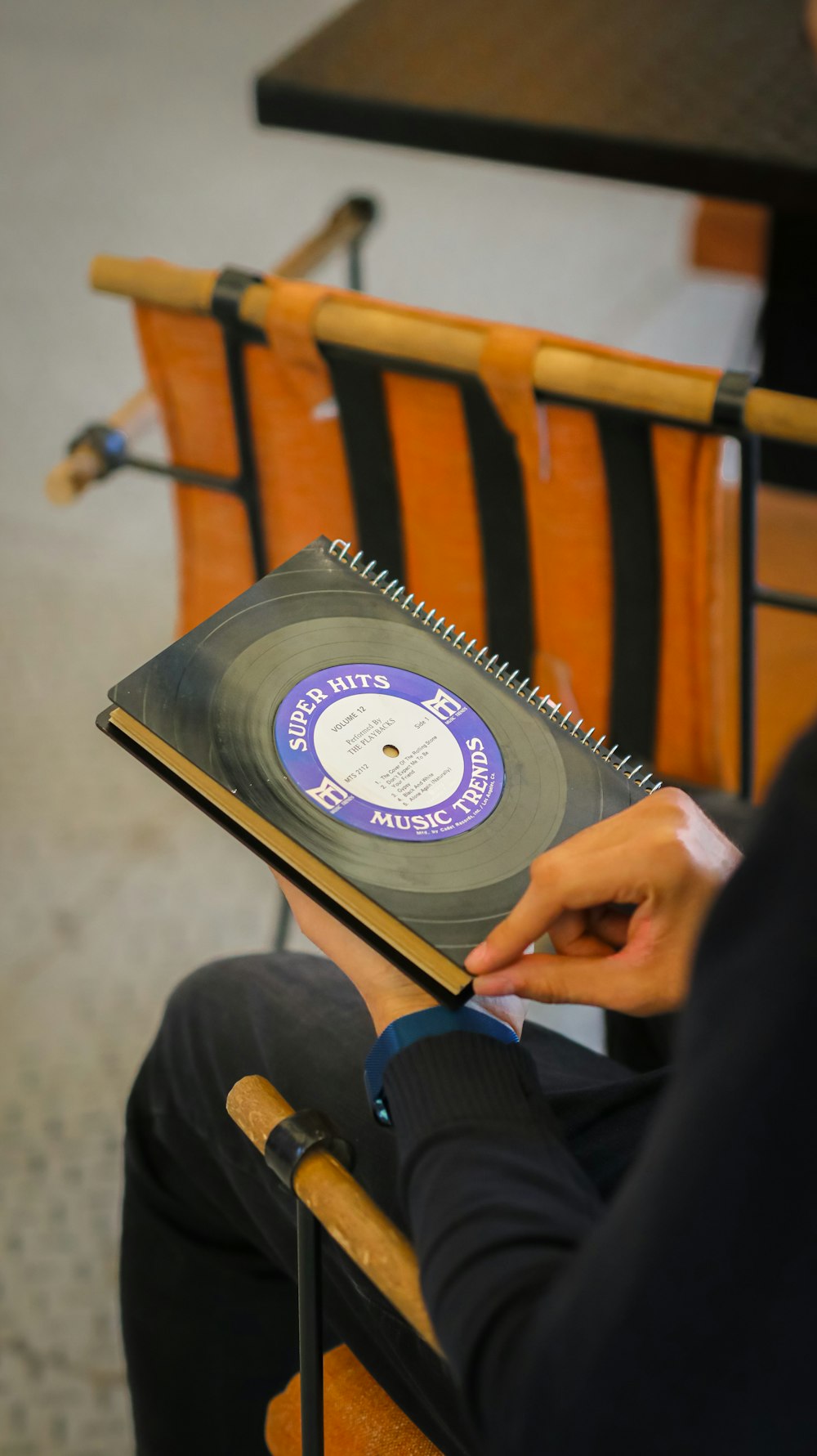 a man sitting in a chair holding a record