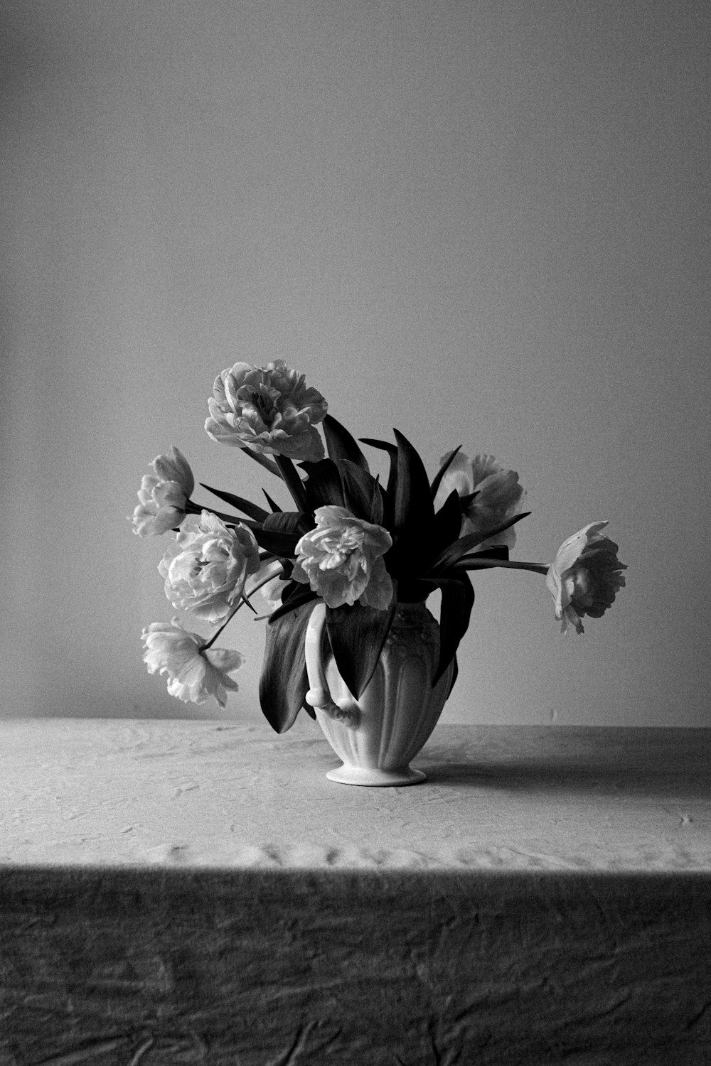 a black and white photo of flowers in a vase