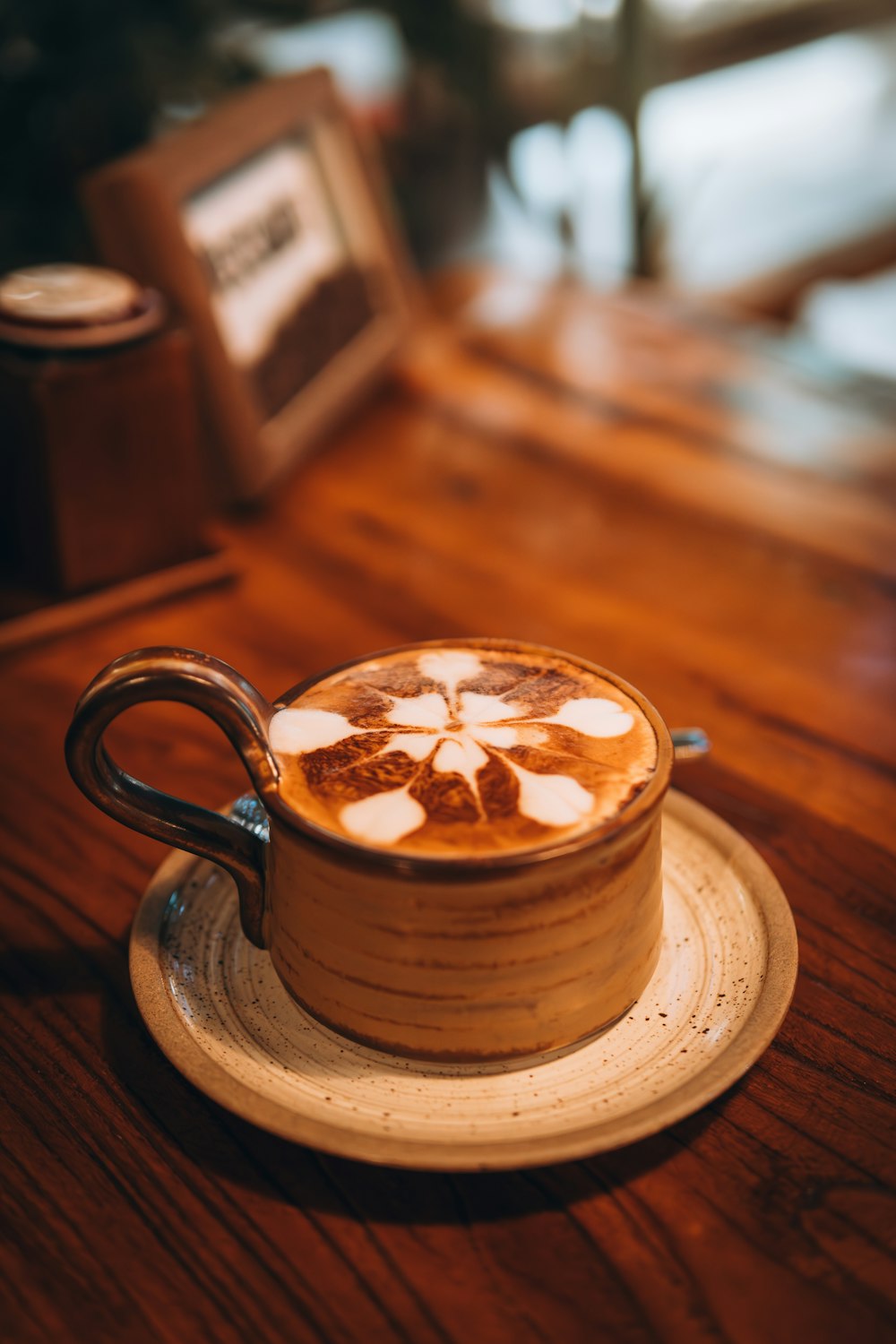 a cappuccino on a saucer on a wooden table