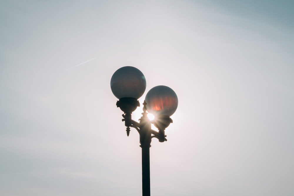 a street light with the sun shining behind it