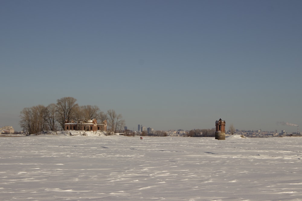 a snowy field with a building in the distance