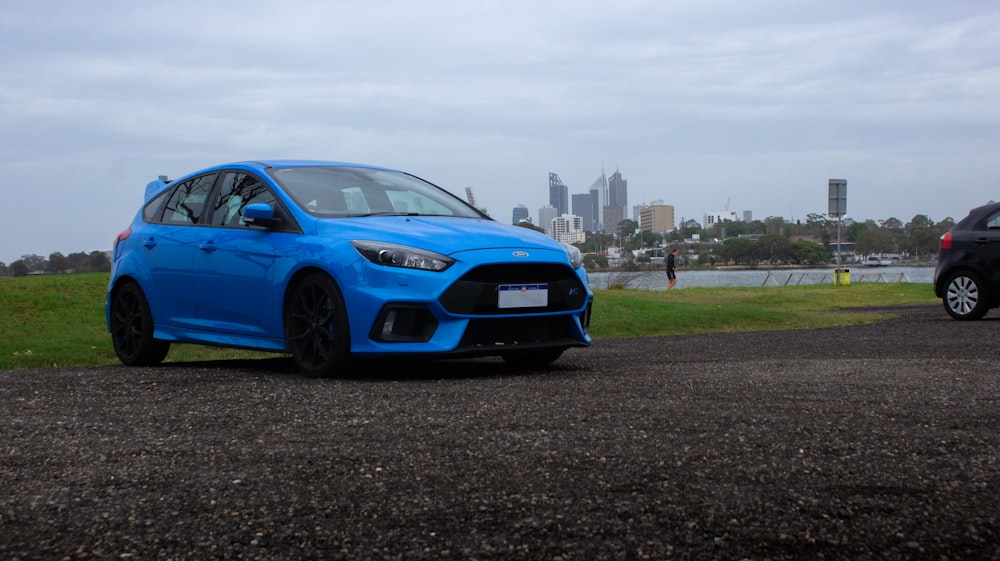 a blue car parked on a gravel road