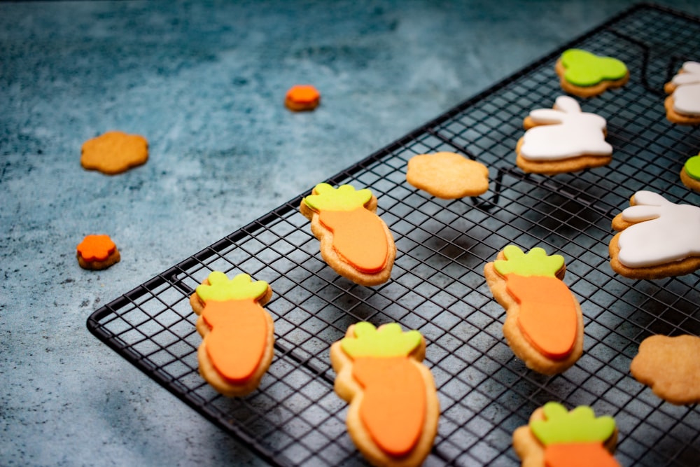 a cooling rack filled with decorated cookies on top of a table