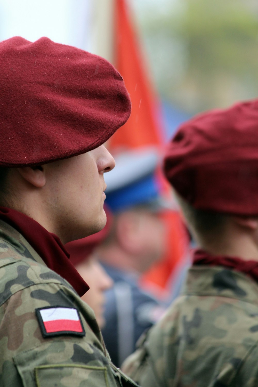 a man in a red beret standing next to another man