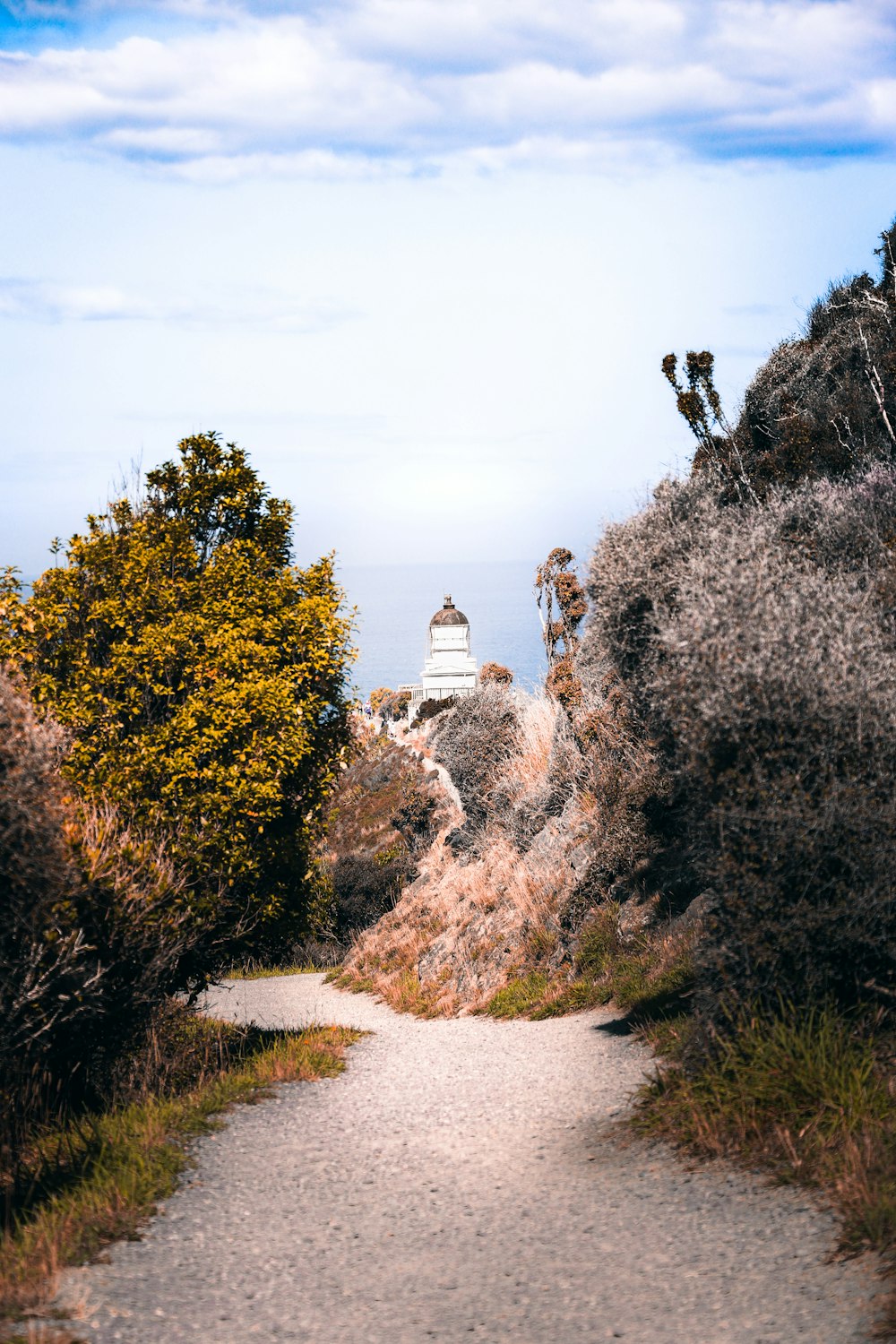 a path leading to a light house on top of a hill