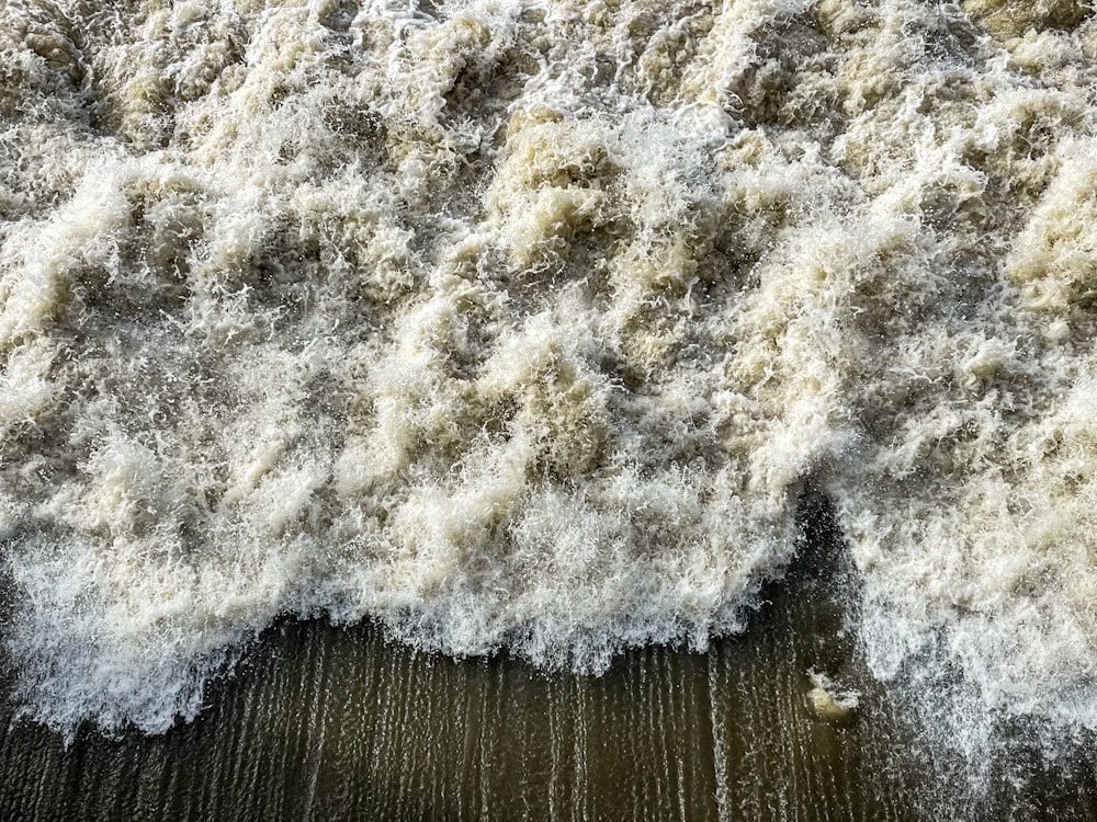 a close up of a wave crashing on a beach